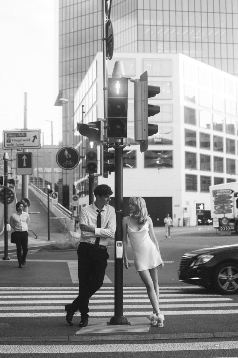 aesthetic black and white photo of a couple leaning agains traffic light