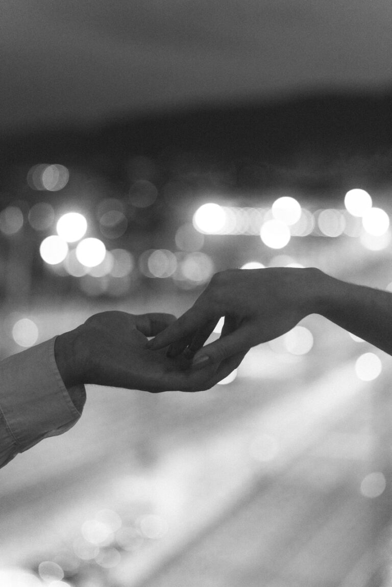 black and white holding hand photo with the background of blurry light from the car