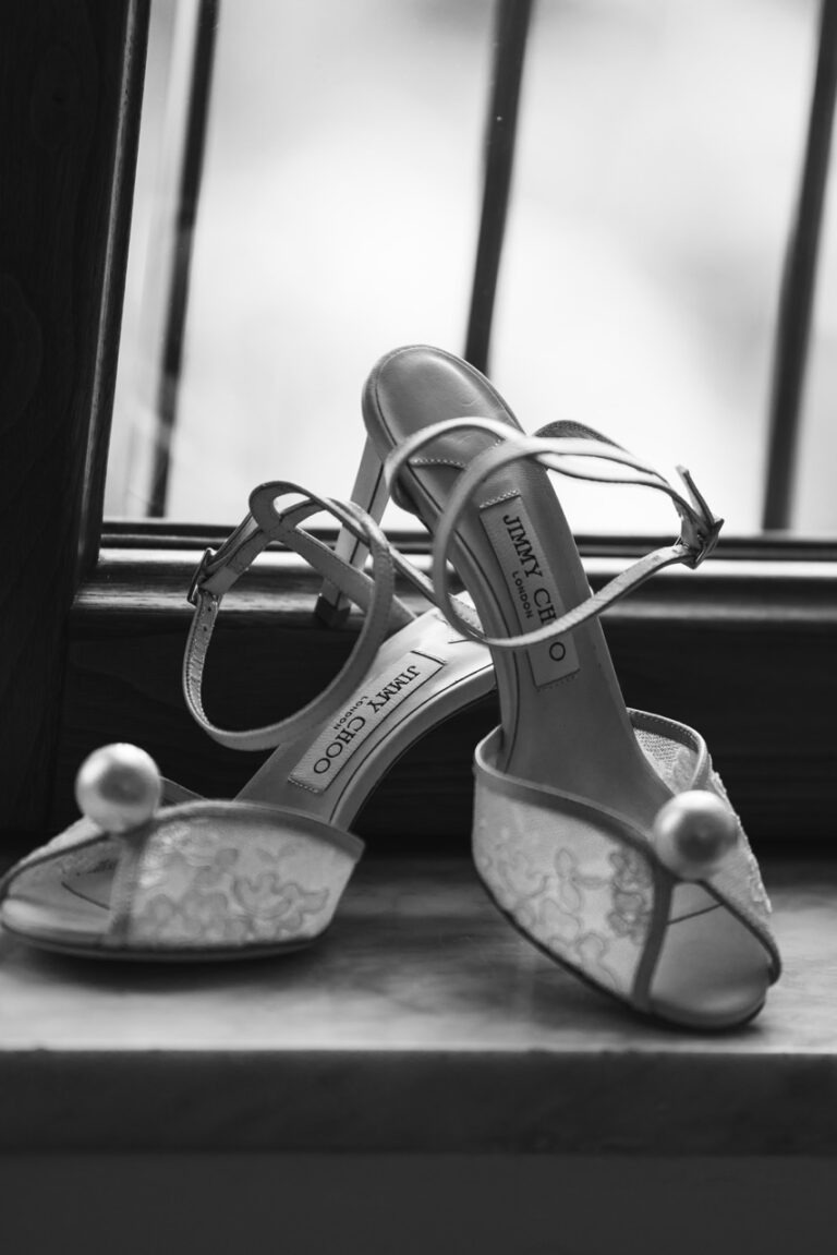 black and white photo of high heel shoes with pears on the shoes